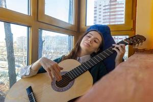 jeune femme jouant de la guitare classique sur le balcon