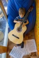 petit garçon joue de la guitare et chante sur le balcon photo