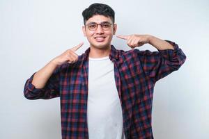 jeune bel homme souriant joyeux montrant et pointant avec les doigts les dents et la bouche. concept de santé dentaire. photo