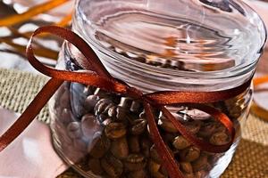 bocal en verre avec des grains de café décorés de ruban photo