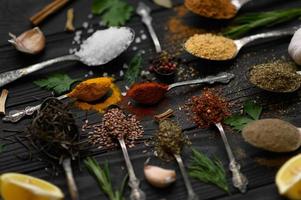 diverses herbes et épices colorées pour la cuisson sur fond rustique en bois foncé photo