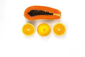 arrangement d'oranges juteuses coupées isolées et d'un morceau de papaye tranché disposé au centre d'un fond blanc, concepts de photographie de fruits sains photo