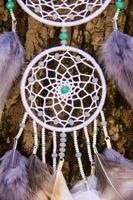 attrape-rêves fait à la main avec des fils de plumes et des cordes de perles suspendues photo