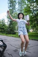 une adolescente en promenade un jour d'été dans le parc déjeune avec des nouilles au wok photo