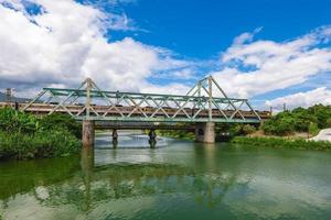 le train passe le pont de fer au parc écologique de la rivière dongshan à yilan, taiwan photo