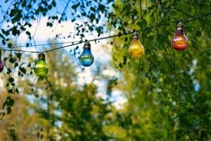 guirlande de lumières accrochée à l'arbre. Garden-party. endroit romantique. lumière colorée photo