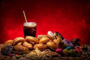 Assortiment de malbouffe de type multiple qui sont dangereux pour la santé sur une table en bois avec copie espace fond clair rouge photo