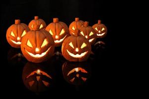 citrouille d'halloween avec des bougies allumées sur fond noir photo