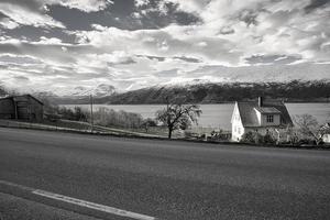 en noir, route blanche au bord du fjord en norvège avec vue sur l'eau et les montagnes photo