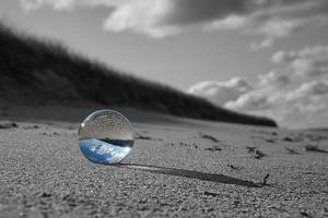 globe de verre sur la plage de la mer baltique. photo