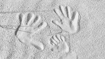 empreintes de mains dans le sable sur la plage de la mer baltique en noir et blanc photo