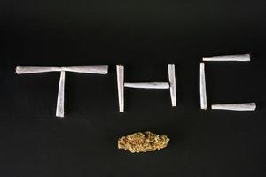 thc écrit avec des joints et des bourgeons de marijuana photo