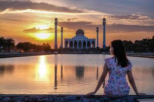 belle fille regardant sur le paysage du beau ciel coucher de soleil à la mosquée centrale de la province de songkhla, au sud de la thaïlande. photo