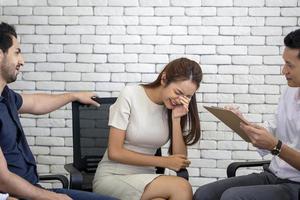 jeune femme d'affaires frustrée et malheureuse tenant la tête dans les mains lors d'une séance de psychothérapie, psychiatre prenant des notes au bureau photo