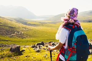 Caucasian female hiker stand profiter du panorama sur la colline sur le sentier de randonnée à l'extérieur en journée ensoleillée sur le trek du lac levanis en géorgie photo