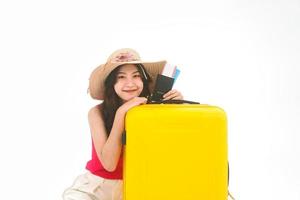 portrait d'une jeune femme asiatique du sud-est adulte avec des bagages de voyage jaunes et un passeport sur fond blanc isolé photo