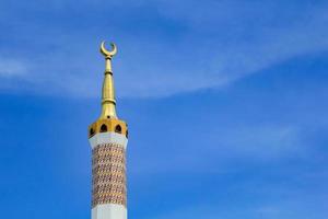 tour de la mosquée islamique traversant le ciel photo