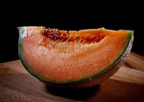 tranche de melon juteux sur une planche de bois. photo