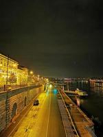 vue nocturne de l'université corvinus de budapest avec le danube et le quai photo