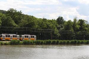 vue sur le tram et le lac budafok avec des arbres verts photo