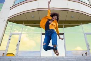 l'heureuse et jeune femme afro-américaine dans la rue s'amusant photo