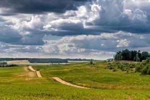 vue panoramique sur la route serpentine sablonneuse laissant au loin et de beaux nuages photo