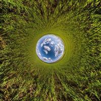 inversion de la transformation de la petite planète du panorama sphérique à 360 degrés. vue aérienne abstraite sphérique dans le champ avec de beaux nuages impressionnants. courbure de l'espace. photo