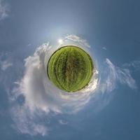 transformation de la petite planète verte du panorama sphérique à 360 degrés. vue aérienne abstraite sphérique dans le champ avec de beaux nuages impressionnants. courbure de l'espace. photo