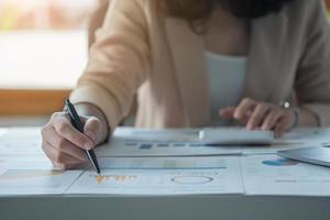 marketing, finance, comptabilité, planification, l'équipe d'hommes d'affaires et d'économistes féminins utilise des calculatrices et des ordinateurs et des documents graphiques au profit de l'entreprise. photo