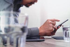 main d'homme d'affaires utilisant des paiements mobiles achats en ligne, crayon, canal omni, ordinateur portable sur un bureau en bois dans un bureau moderne, effet de filtre photo