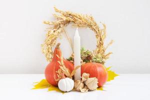 compositions d'automne. feuilles séchées, citrouilles et bougies sur fond blanc. automne automne et concept de jour de thanksgiving. nature morte photo