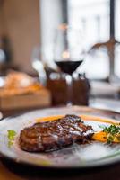 dîner de boeuf plat principal. délicieux dîner avec steak de boeuf sur une assiette sur une table en bois. photo