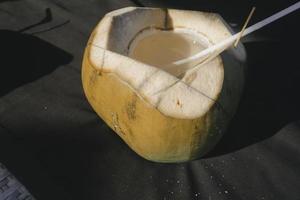 photo de jus de noix de coco frais sur une plage tropicale