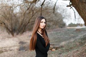 fille élégante debout près de l'arbre au début du printemps. photo