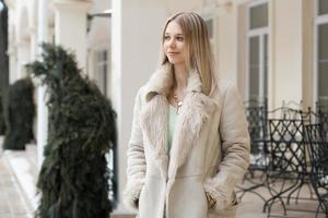 belle fille dans la veste d'hiver debout près du bâtiment photo