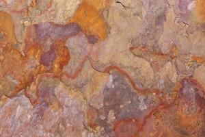 motif d'une plaque de pierre en rouille, orange, beige, violet