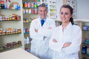 pharmacien souriant et son stagiaire avec les bras croisés photo