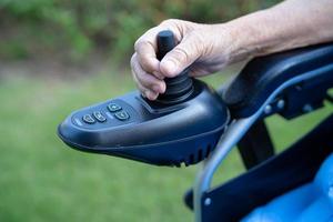 patiente asiatique âgée ou âgée vieille dame sur fauteuil roulant électrique avec télécommande à l'hôpital de soins infirmiers, concept médical solide et sain photo