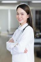 une femme médecin asiatique se tient avec confiance et sourit. photo