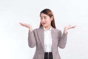 une travailleuse asiatique sourit et montre ses mains pour présenter quelque chose sur le fond blanc. photo