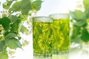 verre de thé chaud au citron vert. fond fleuri. photo