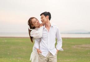 heureux jeune couple asiatique en vêtements de mariée et de marié photo