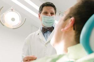 dentiste souriant à un patient satisfait. photo