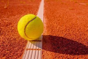 balle de tennis jaune touchant la ligne