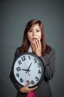 femme d'affaires asiatique surpris tenir une horloge