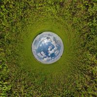 sphère bleue petite planète à l'intérieur de l'arrière-plan du cadre rond de l'herbe verte. photo