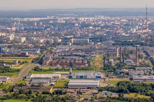 vue panoramique aérienne de la ville et des gratte-ciel avec une immense usine avec des cheminées fumantes en arrière-plan photo