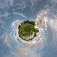 petite planète. vue aérienne sphérique 360 panorama sur la rive du petit lac en soirée d'été ensoleillée avec des nuages impressionnants. photo