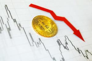 dépréciation de l'argent virtuel bitcoin. la flèche rouge et le bitcoin doré sur l'indice papier du graphique forex baissent sur le fond du marché des changes. concept de dépréciation de la crypto-monnaie. photo