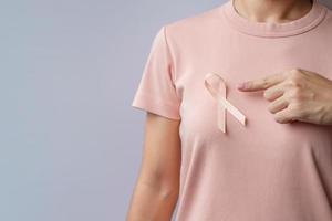 main de femme tenant un ruban de pêche pour le mois de sensibilisation au cancer de l'utérus de septembre. concept de soins de santé et de la journée mondiale du cancer photo